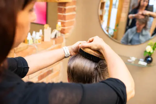 Monika Bürstet mit einer Naturhaarbürste eine Kundin